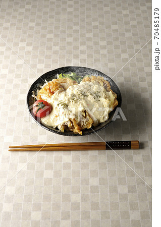 ミニトマトなど野菜も一緒に乗っているタルタルソースたっぷりの熱々チキン南蛮丼とお箸 70485179