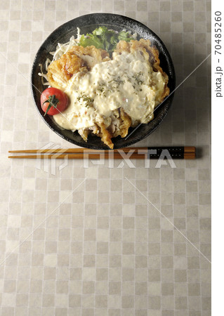 ミニトマトなど野菜も一緒に乗っているタルタルソースたっぷりの熱々チキン南蛮丼とお箸（俯瞰） 70485260