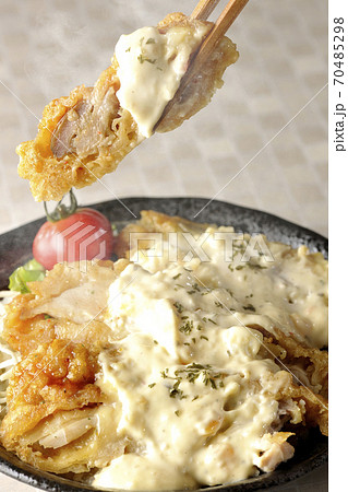ミニトマトなど野菜も一緒に乗っているタルタルソースたっぷりのチキン南蛮丼の一切れを箸でつまんで食べる ミニトマトなど野菜も一緒に乗っているタルタルソースたっぷりのチキン南蛮丼の一切れを箸でつまんで食べる 70485298