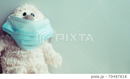 Plush toy medical mask as a concept of self-isolation from coronavirus covid-19 with copy space. Plush toy medical mask as a concept of self-isolation from coronavirus covid-19 with copy space. 70487818