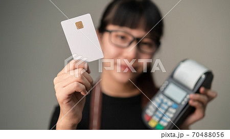 Chip card holding by asian woman in blurry with post terminal or EDC for payment, Concept of contactless card for new way of shopping payment. Chip card holding by asian woman in blurry with post terminal or EDC for payment, Concept of contactless card for new way of shopping payment. 70488056