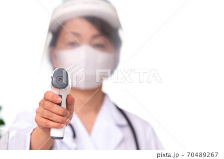 医療　フェイスシールドを付けて検温する女医 70489267