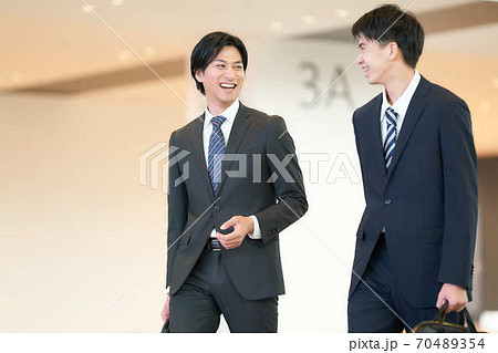 歩きながら談笑するビジネスマン 70489354
