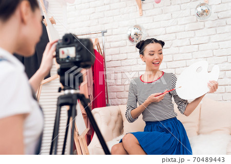 Two fashion blogger girls hold up brush. Two fashion blogger girls hold up brush. 70489443