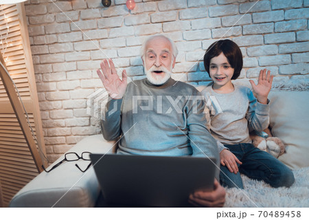 Grandfather and grandson are talking on laptop. 70489458