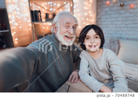 Grandfather and grandson are taking selfie.  70489748