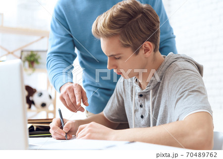 Dad helps son do homework at home 70489762