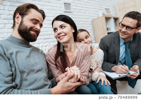 Happy family is sitting on sofa in family psychologist office. Happy family is sitting on sofa in family psychologist office. 70489999