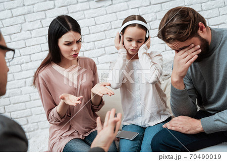 Girl does not listen to parents in headphones. 70490019