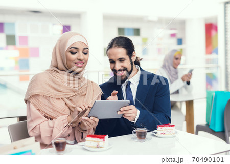 Arabian Couple Sitting in Cafe after Shopping. Arabian Couple Sitting in Cafe after Shopping. 70490101