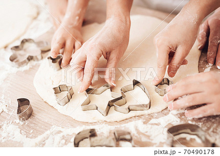 Hands of people cut out cookie cutters for cookies Hands of people cut out cookie cutters for cookies 70490178