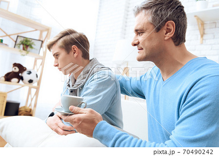 Father tries to drink coffee with his son. Father tries to drink coffee with his son. 70490242