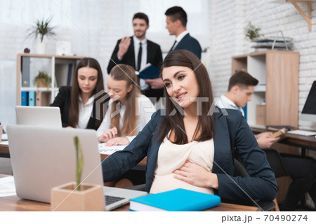 Young pregnant girl works with a young team. 70490274