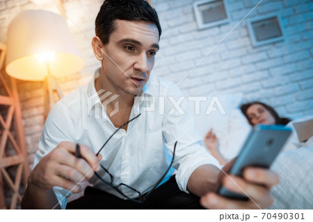 Young businessman in white shirt is holding phone. 70490301