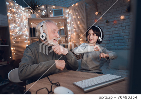 Grandfather with grandson in headphones dancing. Grandfather with grandson in headphones dancing. 70490354