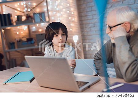 Grandfather and grandson are watching video. Grandfather and grandson are watching video. 70490452