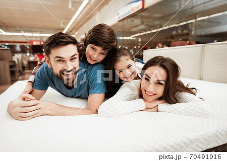Son lay on dad in a mattress store and smiles. Son lay on dad in a mattress store and smiles. 70491016