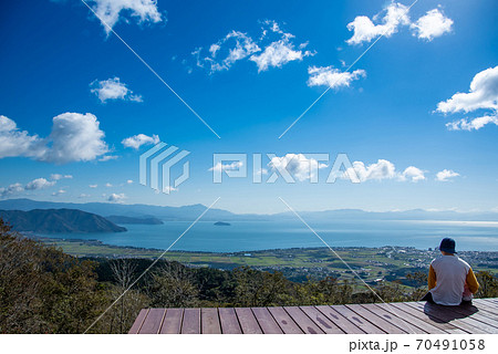 滋賀県高島市　びわこ函館山山頂のびわこ湖の見える丘のデッキに座る人 70491058