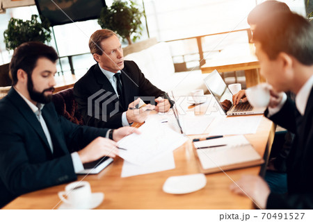 People at table sit and discuss business problems. People at table sit and discuss business problems. 70491527