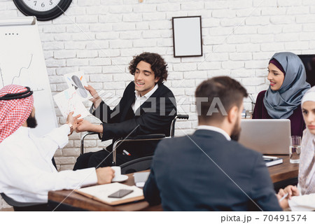 A man is showing something to an Arab colleague. A man is showing something to an Arab colleague. 70491574