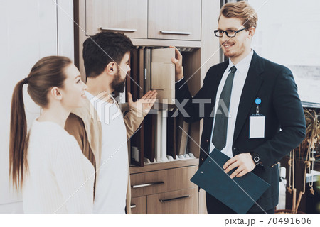 A man in a suit shows repair materials for couple. A man in a suit shows repair materials for couple. 70491606
