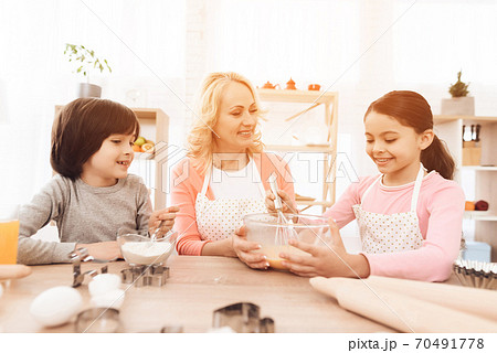 Grandmother with grandchildren in the kitchen. Grandmother with grandchildren in the kitchen. 70491778