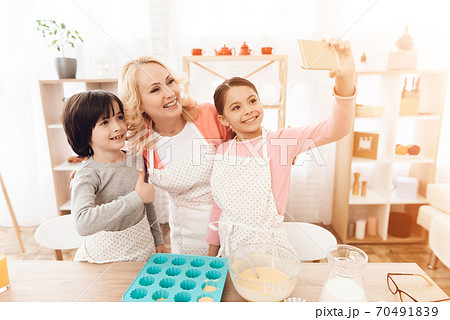 Little granddaughter takes selfie on the kitchen. 70491839