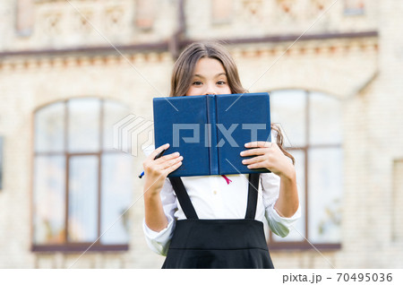 Who picked this book. Adorable small child covering face Who picked this book. Adorable small child covering face 70495036