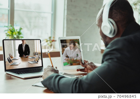 Man working from home, remote office concept. Young businessman, manager doing tasks with laptop, has online conference. Man working from home, remote office concept. Young businessman, manager doing tasks with laptop, has online conference. 70496845