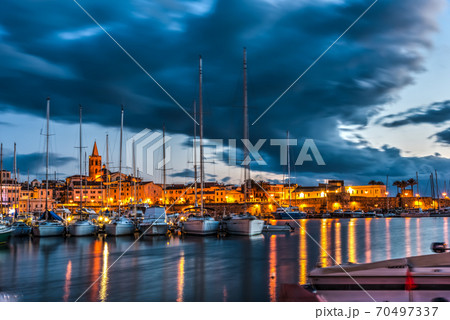 Overcast sky over Alghero harbor at night 70497337