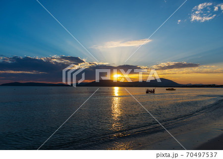 Shining sun and dark clouds in Alghero at sunset Shining sun and dark clouds in Alghero at sunset 70497537