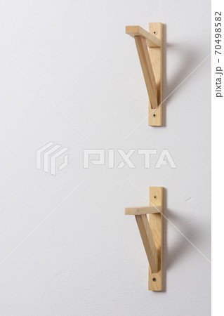 The process of attaching a wooden shelf to the wall 70498582