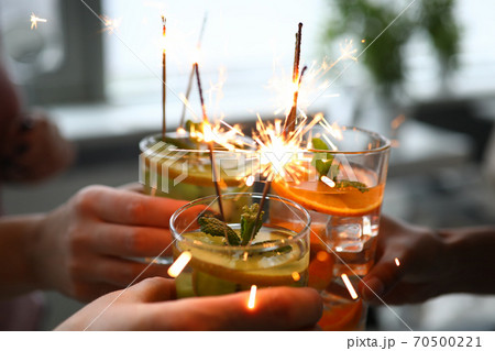 Three alcoholic cocktail with fruit pieces, mint and sparklers close up. Three alcoholic cocktail with fruit pieces, mint and sparklers close up. 70500221