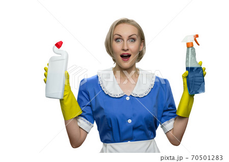 Surprised maid with open mouth holding cleaner spray and toilet disinfectant on white background. 70501283