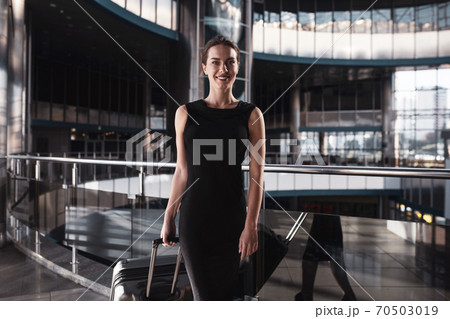 Woman in a black dress visiting an airport Woman in a black dress visiting an airport 70503019