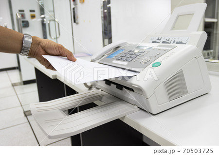 hand man are using a fax machine in the office, equipment for data transmission. hand man are using a fax machine in the office, equipment for data transmission. 70503725