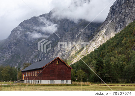 Wooden house in village countryside rocky hills. Mountains near Andalsnes in Norway Wooden house in village countryside rocky hills. Mountains near Andalsnes in Norway 70507674