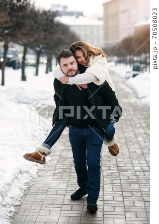 young loving couple on natural winter background. New Year and Christmas. young loving couple on natural winter background. New Year and Christmas. 70508023