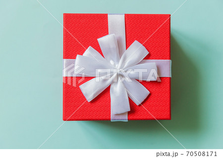 Christmas New Year birthday valentine celebration present romantic concept. Simply minimal design red gift box isolated on pastel blue colorful background. Flat lay top view, copy space 70508171