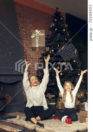 Mother with cute daughter at home near christmas tree 70509455