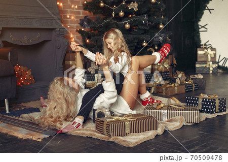 Mother with cute daughter at home near christmas tree 70509478