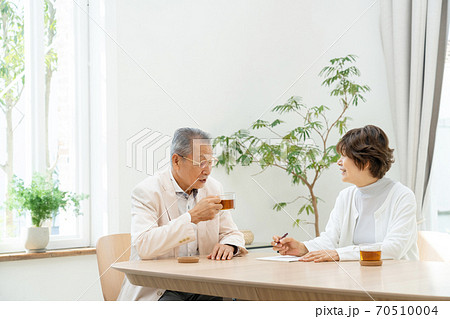 リビングで手紙を書くシニア夫婦 70510004