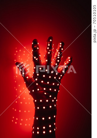human hand covered with red led lights, illuminated background 70510105