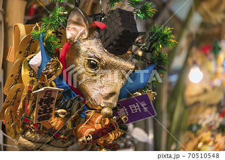 [東京・浅草] 鷲神社の酉の市で販売される小判に囲まれた金色の鼠の頭を飾る縁起熊手。 70510548