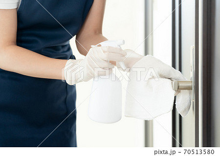 ドアノブを除菌する女性の手元【アルコール消毒】 70513580