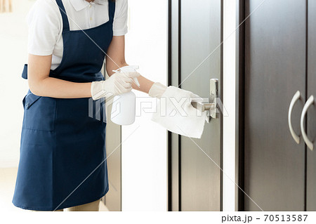 ドアノブを除菌する女性の手元【アルコール消毒】 70513587