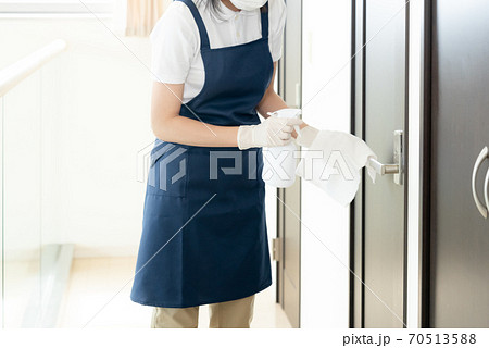 ドアノブを除菌する女性の手元【アルコール消毒】 70513588