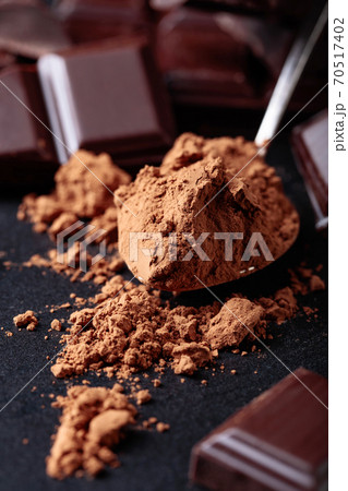Broken chocolate pieces and cocoa powder. Broken chocolate pieces and cocoa powder. 70517402