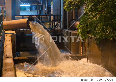 A drain pipe tube, sewage or sewage discharges waste water into a river from factory industry. Water flowing in pollution concept. 70517554