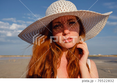 Beautiful young lady with long healthy red hair and cute dress Beautiful young lady with long healthy red hair and cute dress 70522832